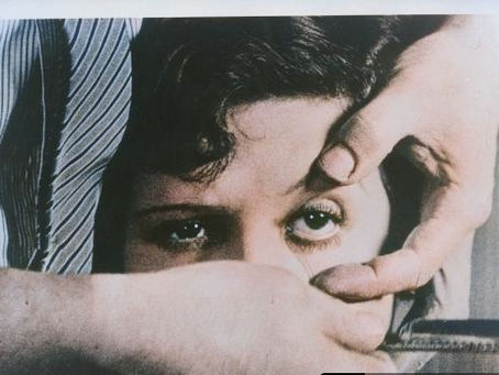 face of a woman, her left eye stretched open by a hand.