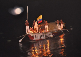 Llegada de la piragua a la tarima fluvial del festival
