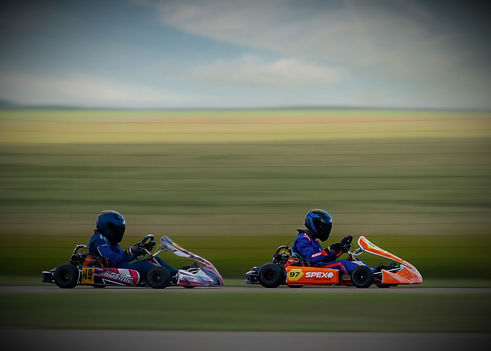 Two people racing in go karts