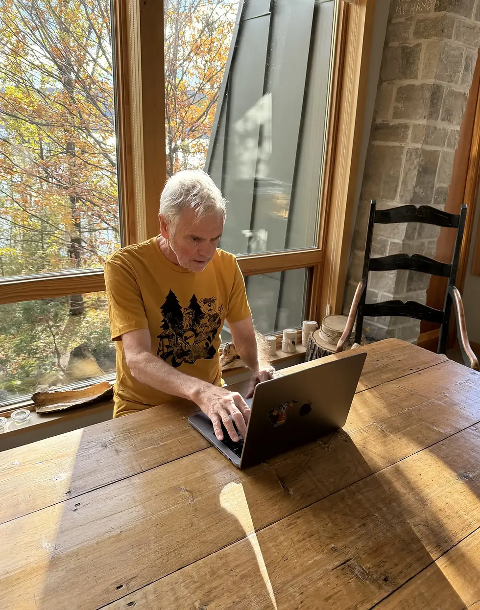 Kevin Gillis, sitting at his kitchen table, writing this blog on his lap top.