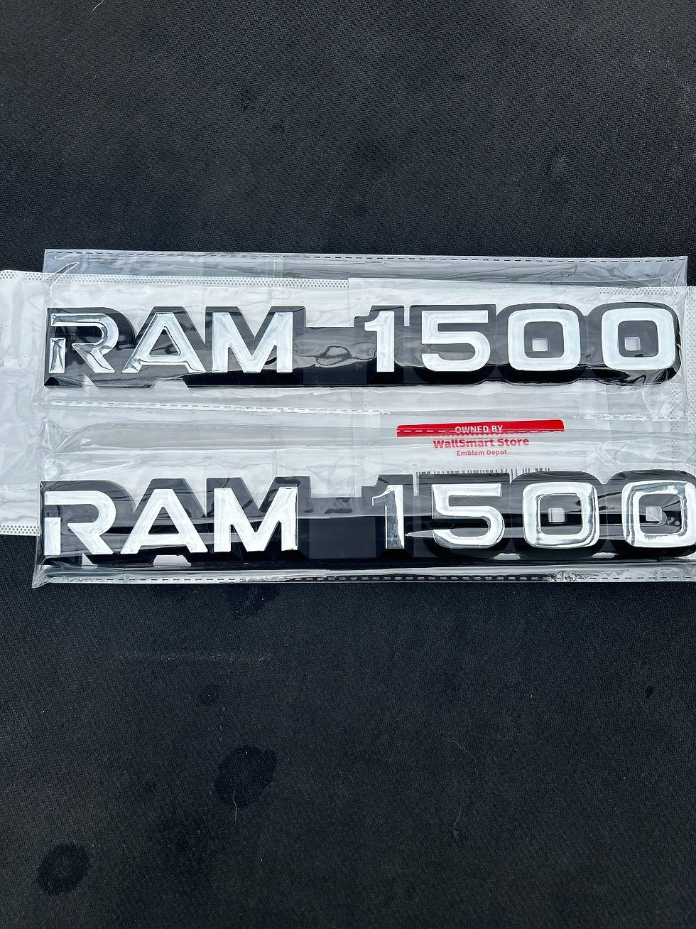 Front view of the 1994-2003 Ram 1500 Fender 55295310 Nameplate Set showing the bright mirror chrome text and black accents