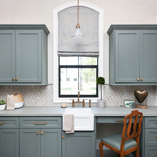 A green grey utility/ laundry room in tomball, tx. mosaic tile on walls between cabinets