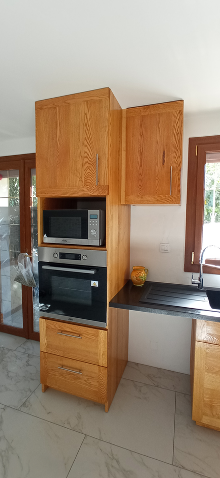 Fabrication sur mesure et pose d'une cuisine en frêne massif, alliant qualité, esthétique et fonctionnalité.