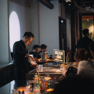 Bartenders working the counter as guests gather during Thịnh Lê's guest shift at oMM Mixology, Saigon
