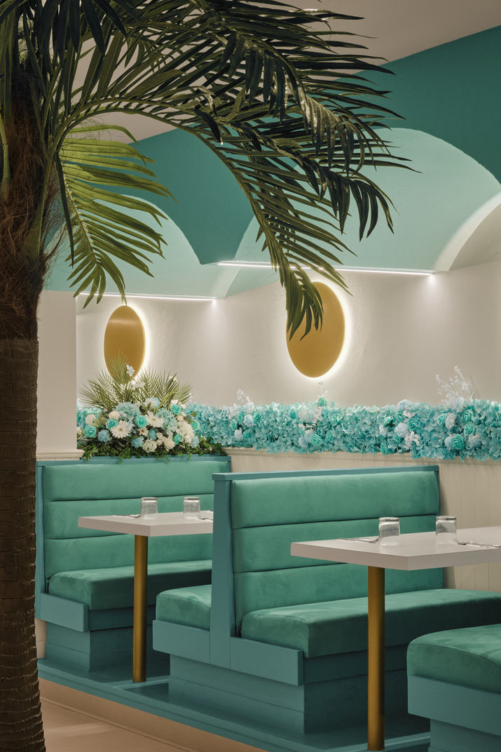 Intérieur d'un restaurant avec des banquettes et des tables, thème tropical, SOLIDO.