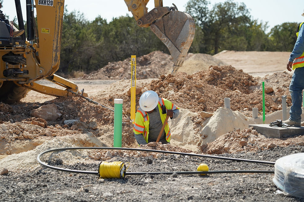 Worker installing underground utilities in an excavation trench..JPG