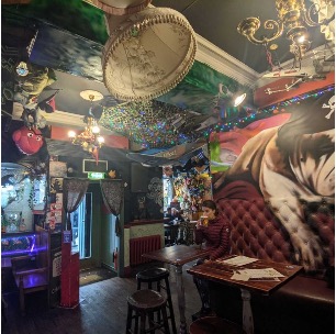 Pub with cool artwork and person drinking a beer