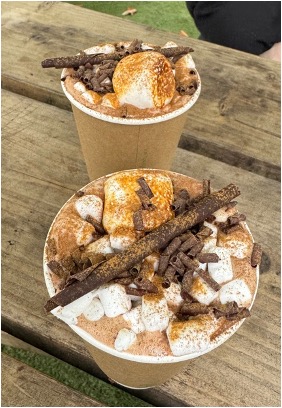 Two hot chocolates with lots of seasoning standing on a wooden table