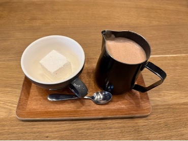 A cup with button and another cup with hot chocolate