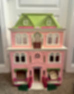 The dollhouse before it was painted. Pink, green, and white.
