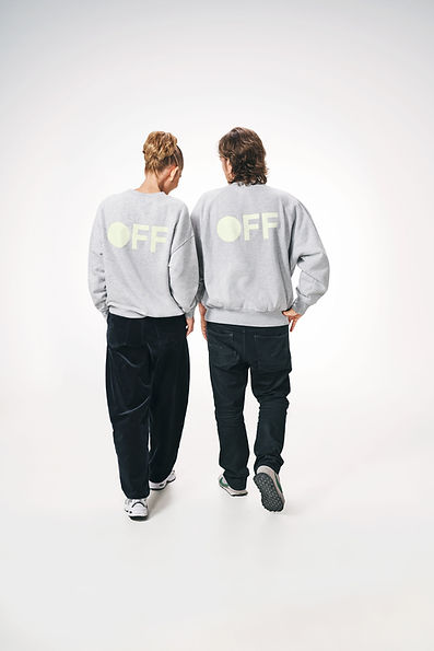 ON | OFF von dean.one – zwei Personen von hinten in grauen Sweatshirts mit fluoreszierendem OFF-Schriftzug