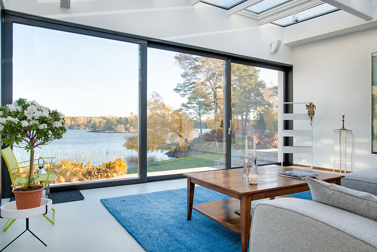 Le salon offre une vue sur la nature et l'eau grâce à une grande fenêtre.