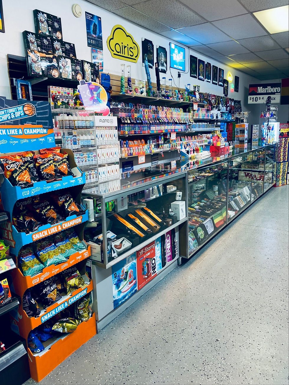 Interior of Lucky Seven Smoke Shop showing long glass display cases filled with vape products, snacks, and accessories, bright and colorful, landscape.