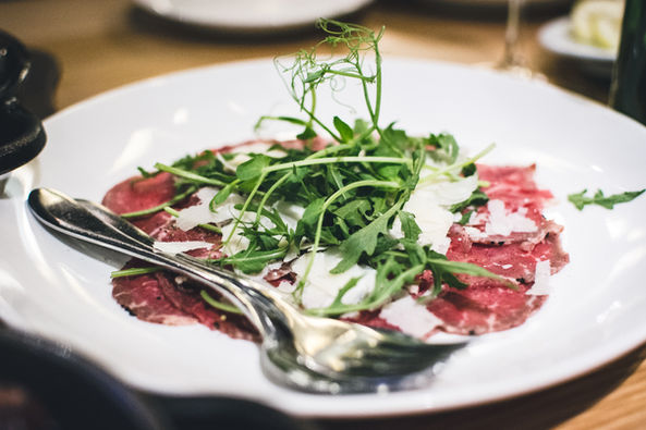 Carpaccio with arugula, parmesan, and sprouts.