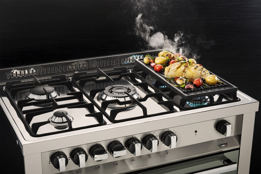 Frango grelhado e vegetais na grelha do fogão.