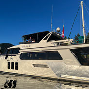The photo of the boat 'we'll sea' with the owners smiling at the top and the water reflecting off the boat 