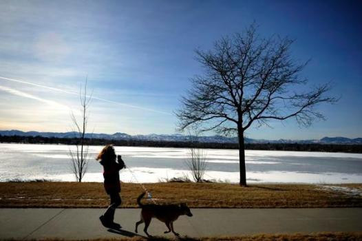 Taking a dog for a walk along a lake.