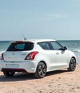 white swift dzire car standing near bea
