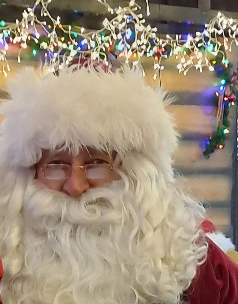 Photo of Santa Claus with a full white beard and fluffy fur hat. Santa Claus is a common story passed down through the generations.
