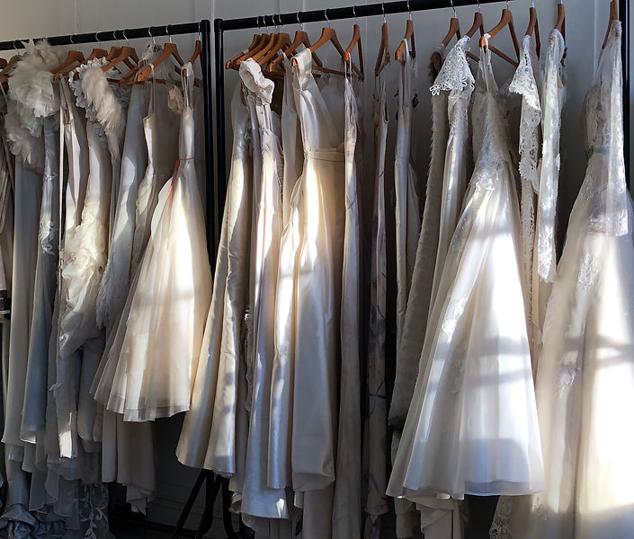 Couture wedding dresses on rail in studio