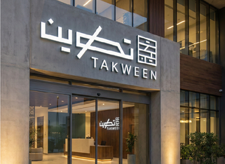 مدخل مبنى مع لافتة تكوين TAKWEEN
