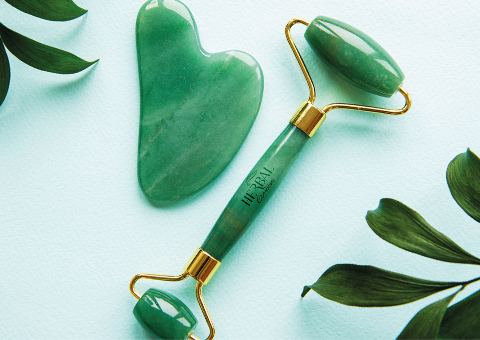 Green jade roller and gua sha on light background.