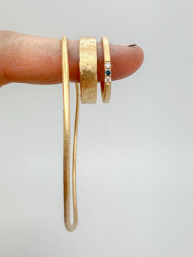 hun trouwringen en een armband, in geelgoud