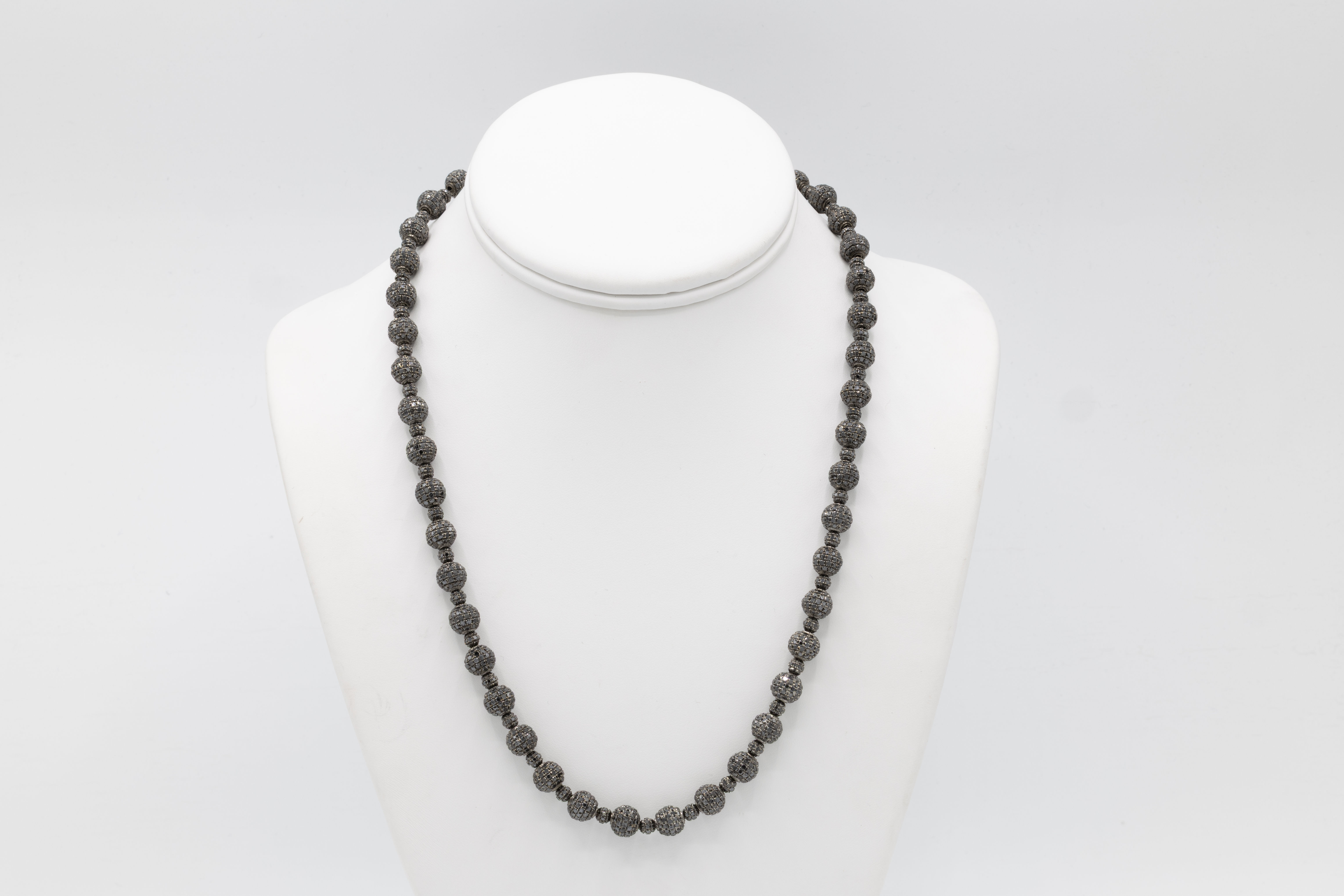 Dark gray beaded necklace displayed on a white mannequin, Ofira Jewels.