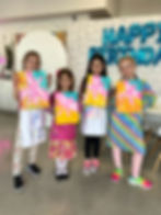 4 girls standing holding painting projects of pink butterflies