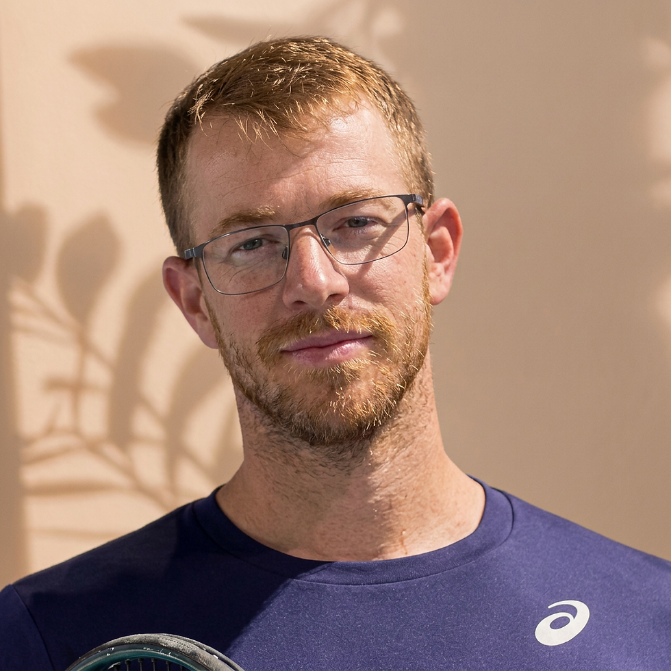 Digital portrait photography of a man with glasses and a beard. He wears a dark athletic shirt, suggesting a sports or coaching context.