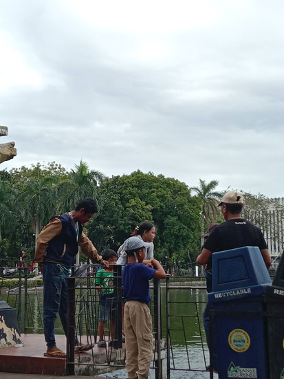 people watching and feeding fishes