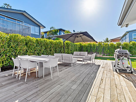 a freshly renovated hotel pool area with new contrete tiles, black fence and furniture
