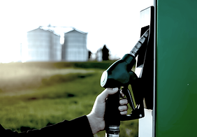 green-hvo-biofuel-pump-held-by-person-reflective-safety-vest-with-industrial-tanks (1).png