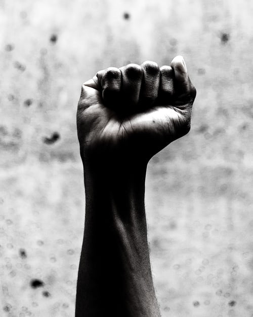 Image of Black person's fist raised in the air as a representation of Black power