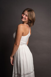 Menifee high school senior peering over her shoulder in a cute white dress