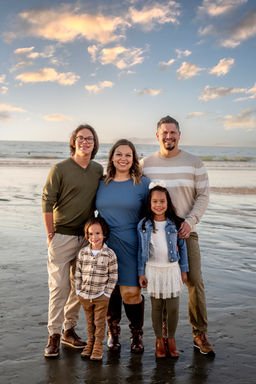 Family of 5 wading in the water at a beach in La Jolla, California