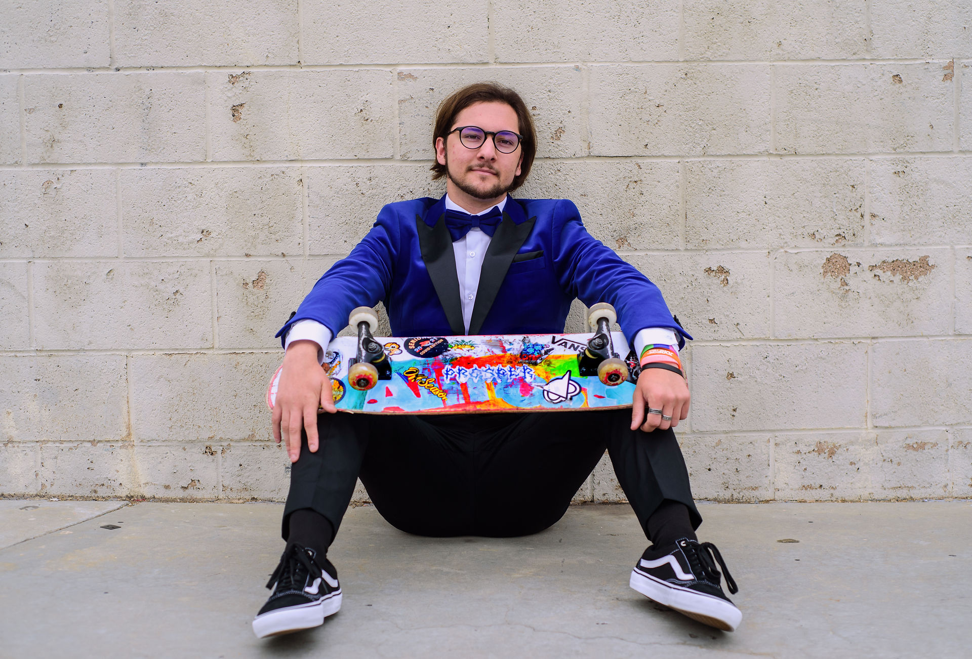 Tuxedo-clad teen holding skateboard