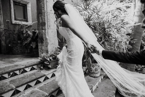 Foto en blanco y negro de Daniela subiendo los escalones mientras Sergio sostiene la mano de ella.