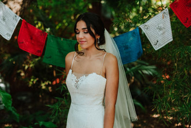 La novia posa bajo los banderines mirando hacia un costado dentro del jardín.