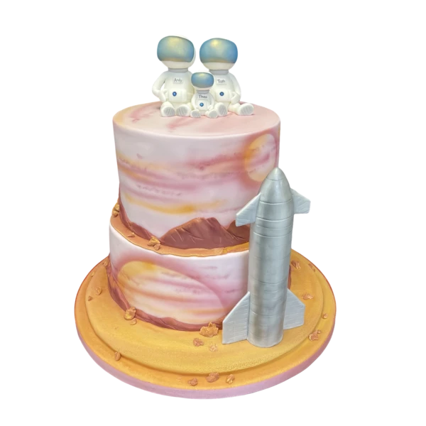 Two-tier wedding cake with sugar paste astronauts, sunset colours, and a silver rocket.