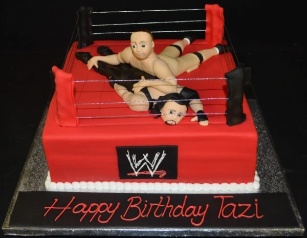 A WWE wrestling ring inspired cake with detailed decorations, perfect for wrestling fans and themed parties.