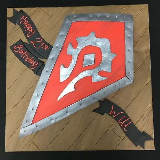Bespoke Warhammer shield cake with intricate silver and red detailing, crafted for celebration in Solihull, West Midlands.