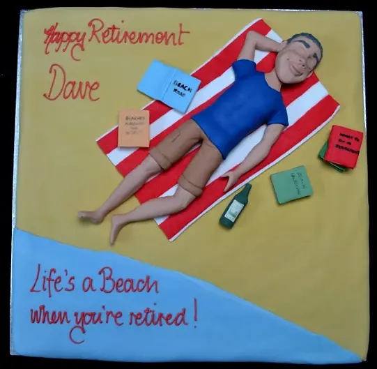Bespoke cake featuring a sunbathing man figure on a sandy beach design, crafted in Solihull, West Midlands.