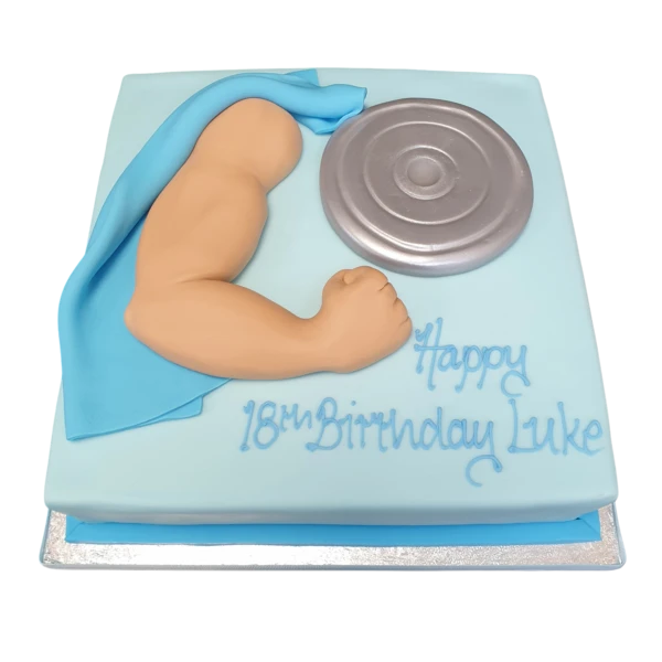 A muscular arm-shaped cake decorated with a towel and weight, perfect for fitness enthusiasts and gym lovers looking for a unique cake design in the UK.