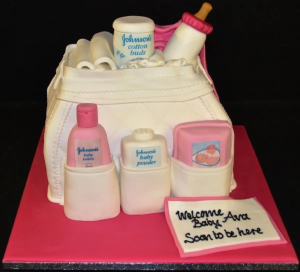 Bespoke baby changing bag cake with pastel colors and edible baby accessories, crafted in Solihull, West Midlands.