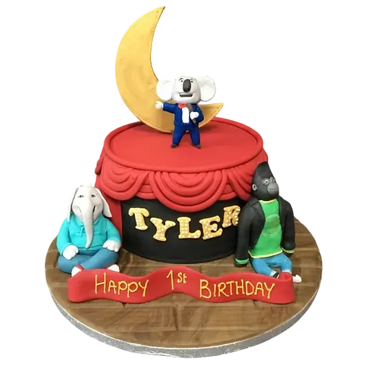 Bespoke cake featuring singing animal figures with red curtains, crafted for celebration in Solihull, West Midlands.