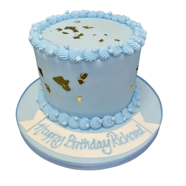 A stunning cake decorated with elegant shell patterns and shimmering gold leaf accents, perfect for a special occasion or celebration.