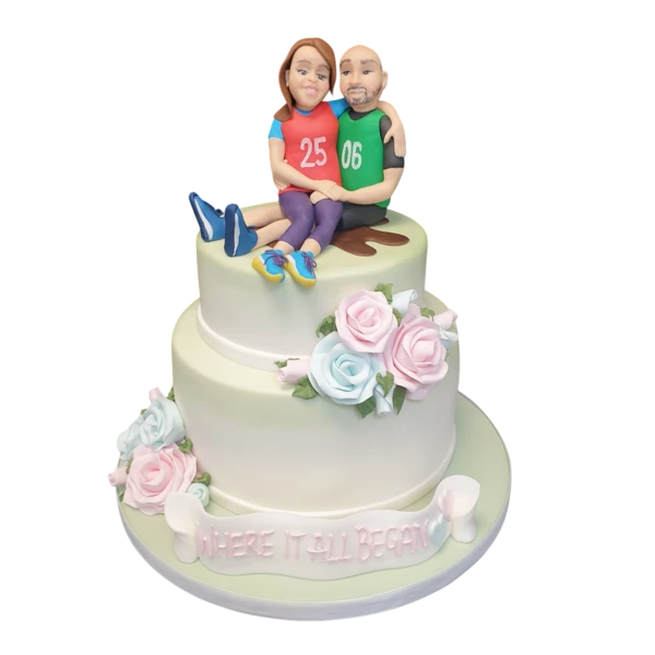 Two-tier wedding cake with pastel sugar roses and personalised topper.
