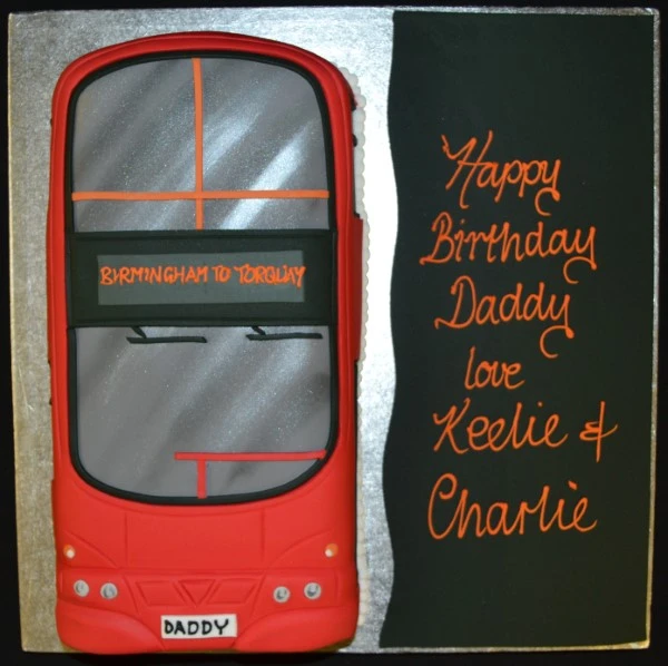 Bespoke cake shaped like a WM Travel bus front with detailed windows and logo, crafted in Solihull, West Midlands.
