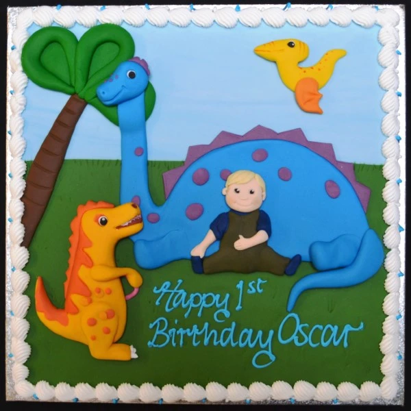 Custom-made fondant cake with a boy figurine playing with a dinosaur toy on top, perfect for dinosaur-loving kids' parties or celebrations.